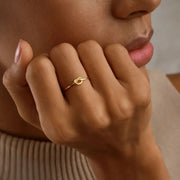 Close-up of a hand wearing a 14k gold filled knot ring with a minimalistic design.